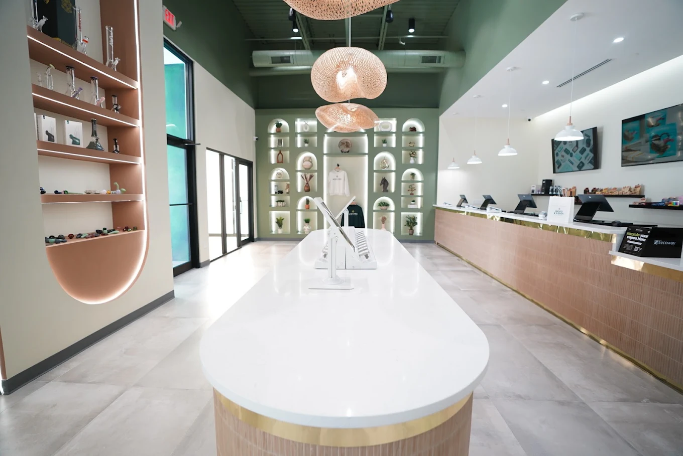 Interior of a cannabis dispensary with white counter and green accent wall